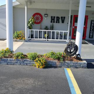 A welcoming entrance featuring landscaped greenery and a prominent sign.