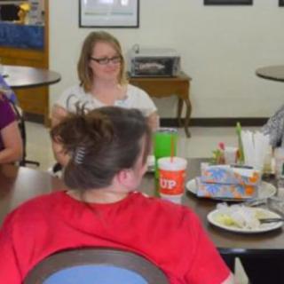 A group of people sitting around a table enjoying a meal together indoors.