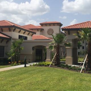 A large residential house with a red-tiled roof and landscaped garden.