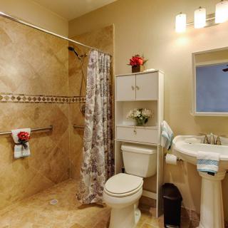 A well-organized bathroom with a shower, toilet, and pedestal sink.