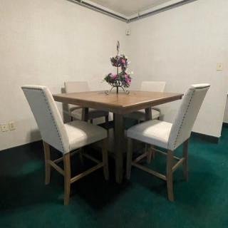 A cozy dining area with a wooden table and cushioned chairs, complemented by a decorative centerpiece.