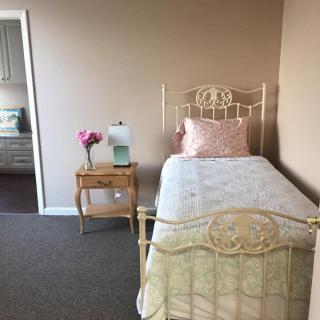 A quaint bedroom with a vintage single bed and a decorative nightstand.