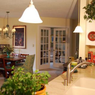 A cozy kitchen and dining area with warm lighting and greenery.