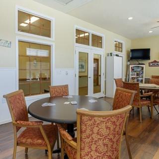 A community room with tables, chairs, and a television.