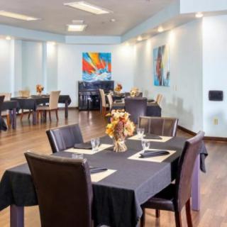 A modern restaurant dining area with neatly arranged tables and contemporary artwork on the walls.