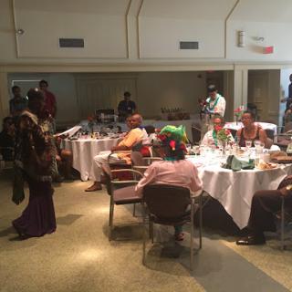A lively gathering with guests enjoying a meal in a decorated dining space.