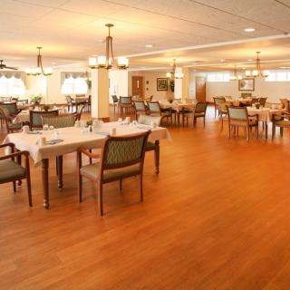 A spacious and well-lit dining area with neatly arranged tables and chairs.