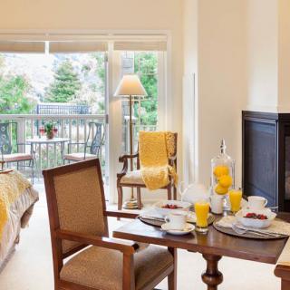 A cozy dining and living area with a breakfast setup and a view of the balcony.