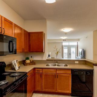 A modern kitchen with wood cabinets and various appliances.
