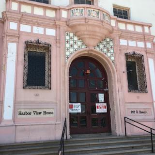 The ornate entrance of a historical building featuring a pink facade and decorative tiles.