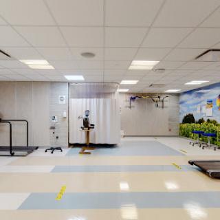 A spacious therapy room equipped with medical devices, designed for rehabilitation and physical therapy.