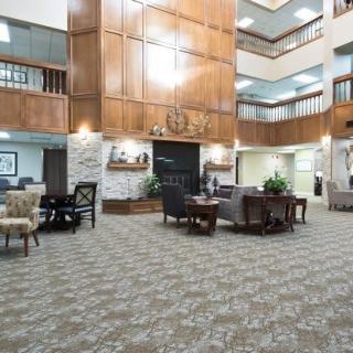 A spacious hotel lobby with wood-paneling, various seating areas, and an open atrium design.