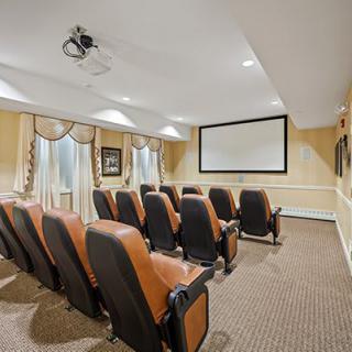 A cozy home theater room with comfortable seating and a large projection screen.