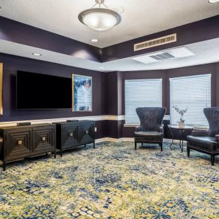 A modern lounge area with comfortable seating, a large television, and stylish decor.