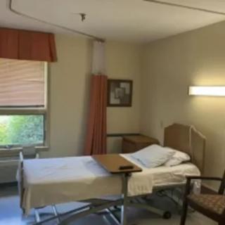A quiet hospital room with a single bed and window.