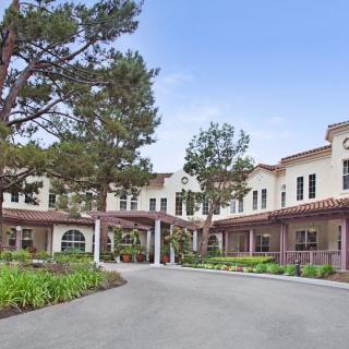 A residential building surrounded by trees and landscaping during the daytime.