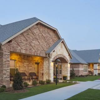 A suburban brick building with a well-maintained lawn and driveway.