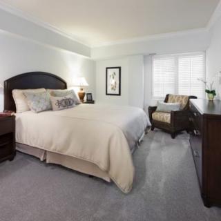 A cozy bedroom with a neatly made bed and elegant furnishings.