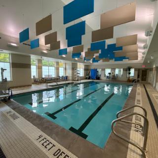 A modern indoor swimming pool featuring vibrant blue and beige accents for a refreshing atmosphere.