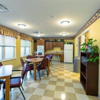 A spacious kitchen and dining area with tables, chairs, and various appliances.