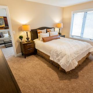 A cozy and well-decorated bedroom featuring a comfortable bed, stylish nightstands, and warm lighting.