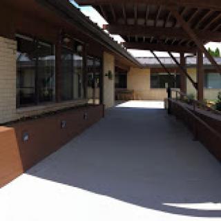 A well-lit outdoor walkway connected to a building, featuring modern architectural design.