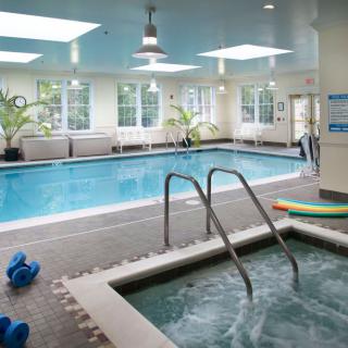 An indoor swimming pool and hot tub area with relaxation amenities.