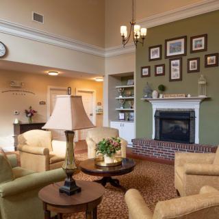 A cozy living room with comfortable seating and a decorated fireplace.