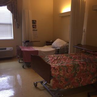 A quiet hospital room with two beds separated by curtains.