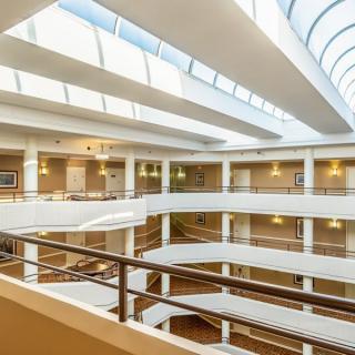 A modern multi-level atrium with skylights and railings.