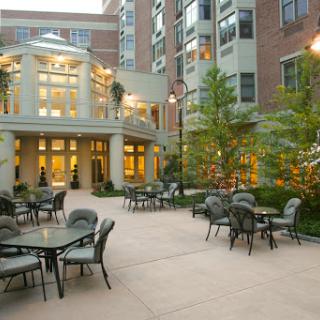 A serene courtyard with outdoor seating surrounded by modern architecture and lush landscaping.