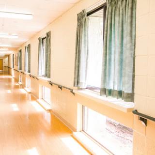 A bright and clean hallway with windows draped in curtains.