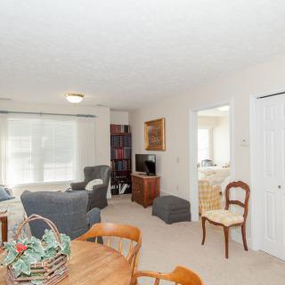 A cozy living room with a dining area, featuring comfortable seating and ample natural light.