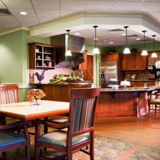 A modern kitchen and dining area with wooden cabinets, a dining table, and cozy lighting.