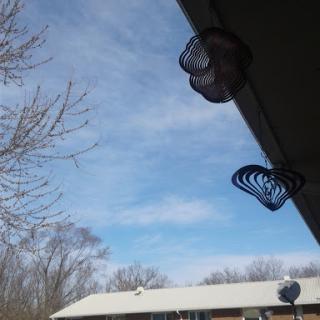A clear blue sky with some scattered clouds, featuring hanging decorations near the roof.