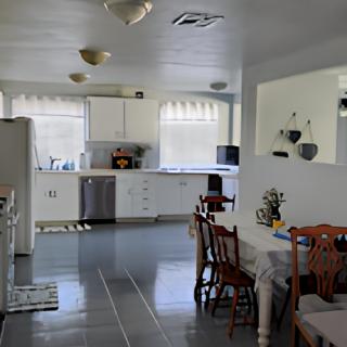 A bright kitchen and dining area with white cabinets and modern appliances.