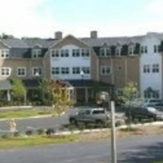 A residential building with a parking lot in front.