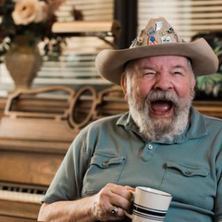 A joyful man enjoying a cup of coffee, surrounded by charming decor.