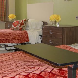 A hospital room with two beds and bedside tables.