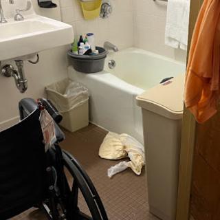A bathroom equipped for accessibility, featuring a wheelchair and a bathtub.