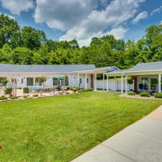 A suburban house with a well-maintained lawn and surrounding trees.
