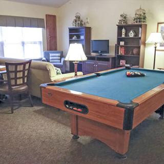 A cozy living room featuring a pool table and comfortable seating.