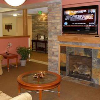A cozy living room featuring a fireplace, television, and a coffee table with decorative items.