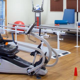 A rehabilitation room equipped with various physical therapy machines and exercise equipment.