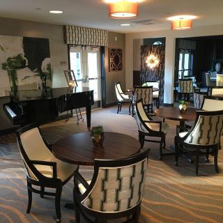 A contemporary lounge area featuring elegant seating, a grand piano, and stylish lighting.