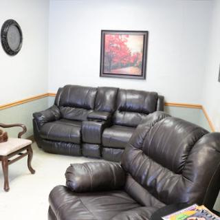 A cozy living room setup featuring leather furniture and decorative wall art.
