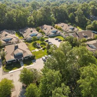 Aerial view of a quiet suburban neighborhood surrounded by trees.