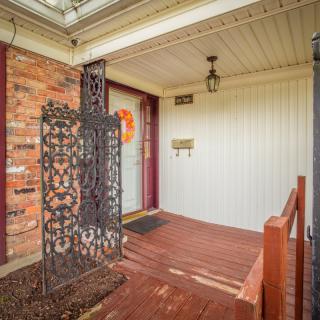 A cozy front porch with a brick wall and decorative elements.
