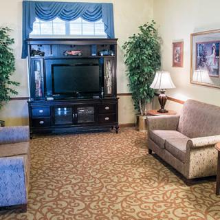 A cozy living room with comfortable seating, a TV stand, and decorative elements.