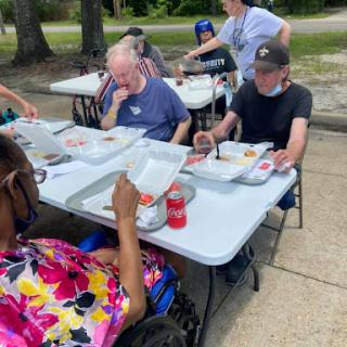 A group enjoying a meal together outdoors, fostering community spirit and connection.